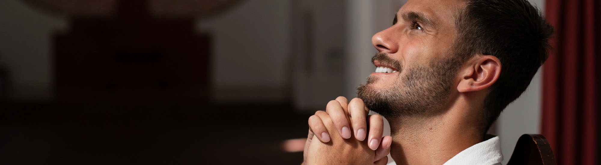 A smiling man praying while looking towards the sky | Most Holy Eucharist